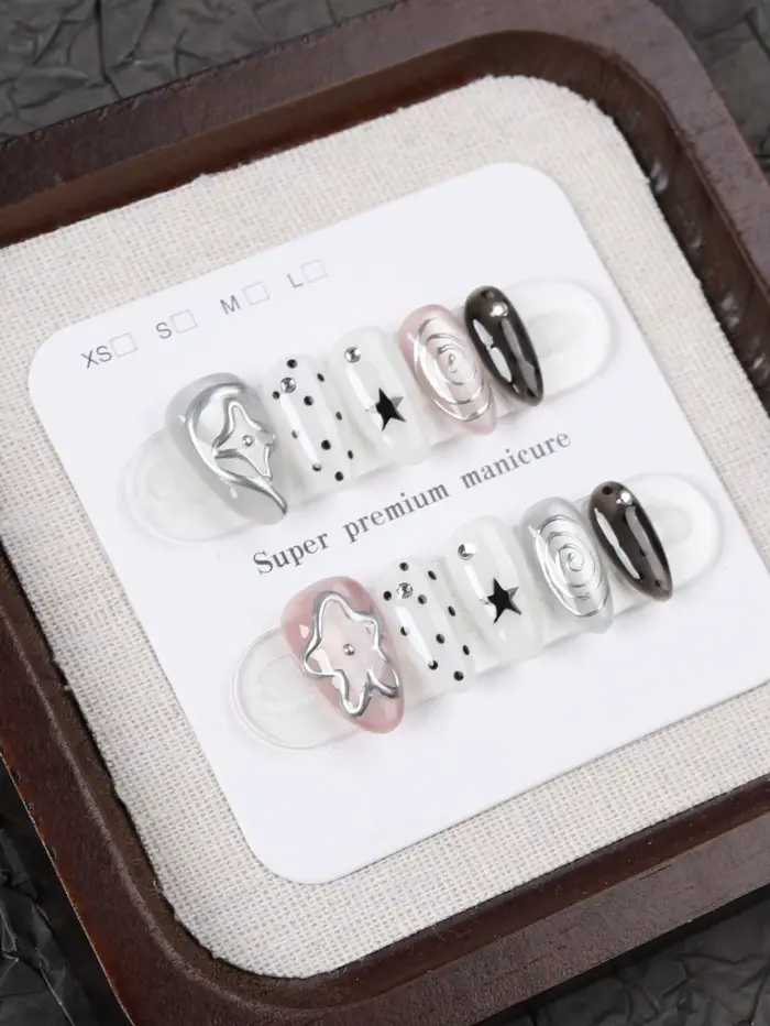 10 faux ongles de taille moyenne en forme d'amande, style Millennium Dark avec des pois étoilés noirs et blancs, ornés de motifs tourbillonnants argentés métalliques et de décorations étoiles 3D Faux