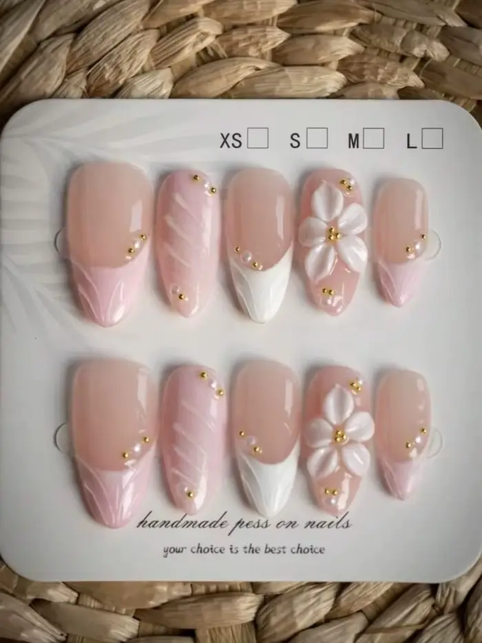 10 faux ongles faits à la main en forme d'amande, avec délicats pétales rose nude, dans un style fra