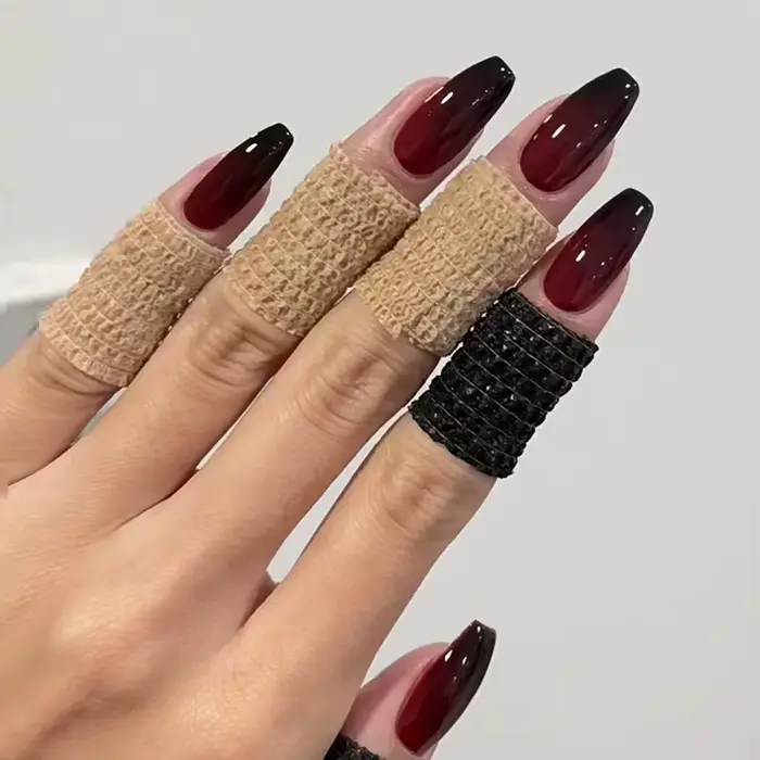 Presse gothique rouge foncé sur les ongles