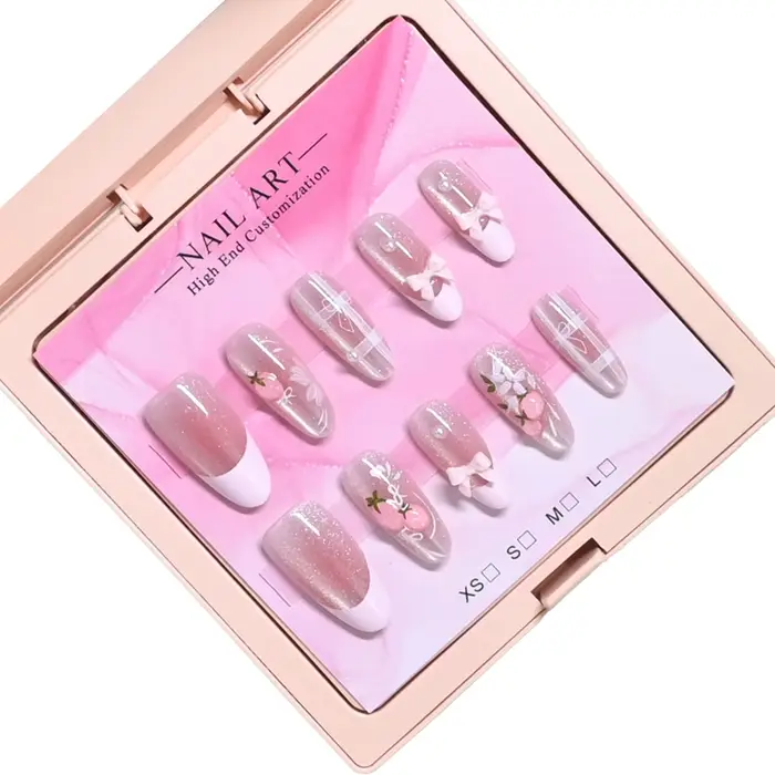 10 ongles d'amande faits à la main dans un étui rose miroir. Base nude pailletée avec motif français