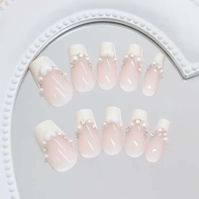 Faux ongles courts en press-on jaune crème style ballerine avec perles blanches et strass