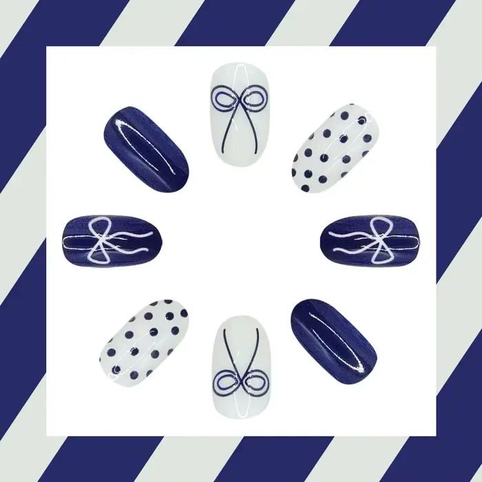 Faux ongles courts arrondis bleu profond avec papillon à pois
