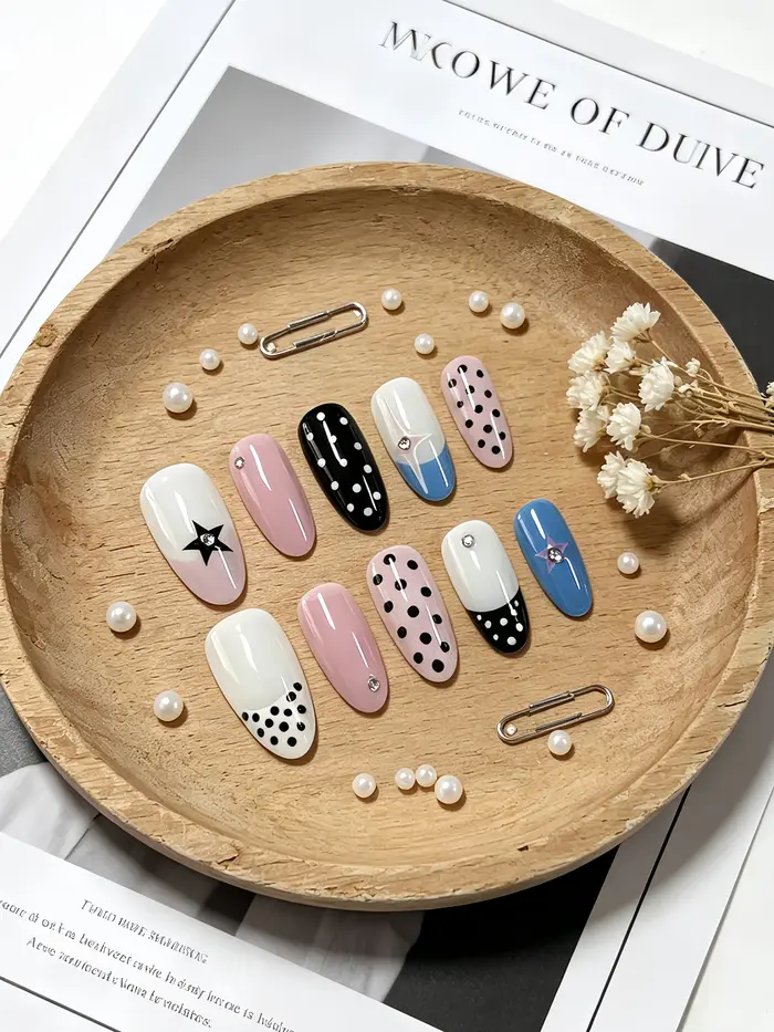 10 faux ongles courts en forme d'amande, aux couleurs principales blanc laiteux, bleu clair, noir pur et rose clair, avec des embellissements en strass en forme d'étoiles et de pois, style gothique, f