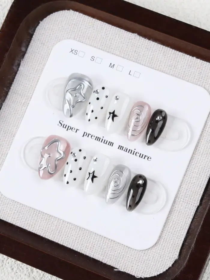 10 faux ongles de taille moyenne en forme d'amande, style Millennium Dark avec des pois étoilés noirs et blancs, ornés de motifs tourbillonnants argentés métalliques et de décorations étoiles 3D Faux