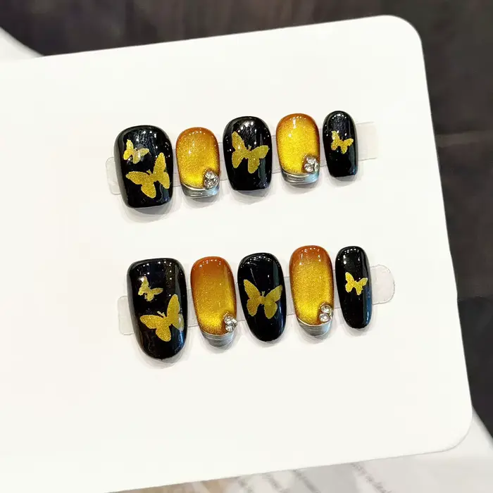 10 faux ongles faits à la main avec motif papillon doré et effet œil de chat noir