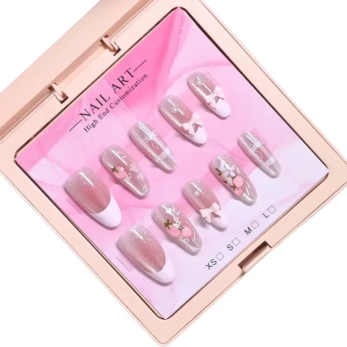 10 ongles d'amande faits à la main dans un étui rose miroir. Base nude pailletée avec motif français blanc