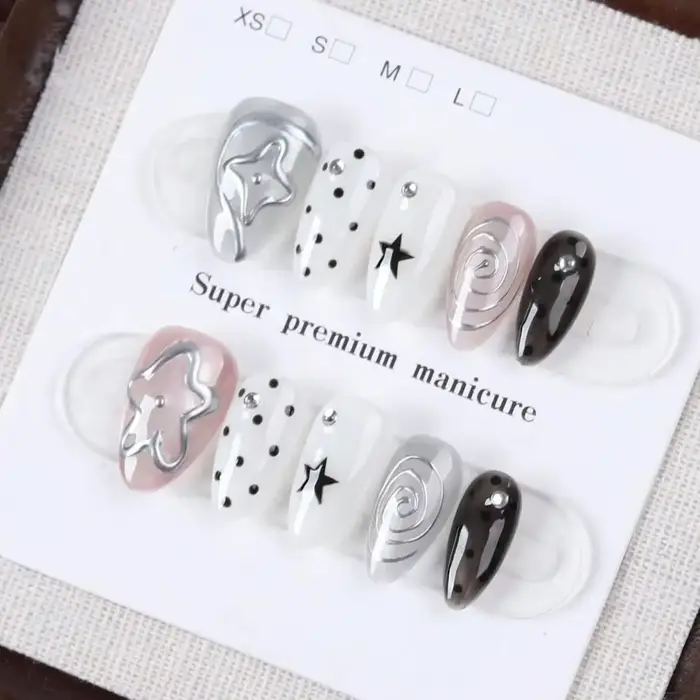 10 faux ongles de taille moyenne en forme d'amande, style Millennium Dark avec des pois étoilés noirs et blancs, ornés de motifs tourbillonnants argentés métalliques et de décorations étoiles 3D Faux