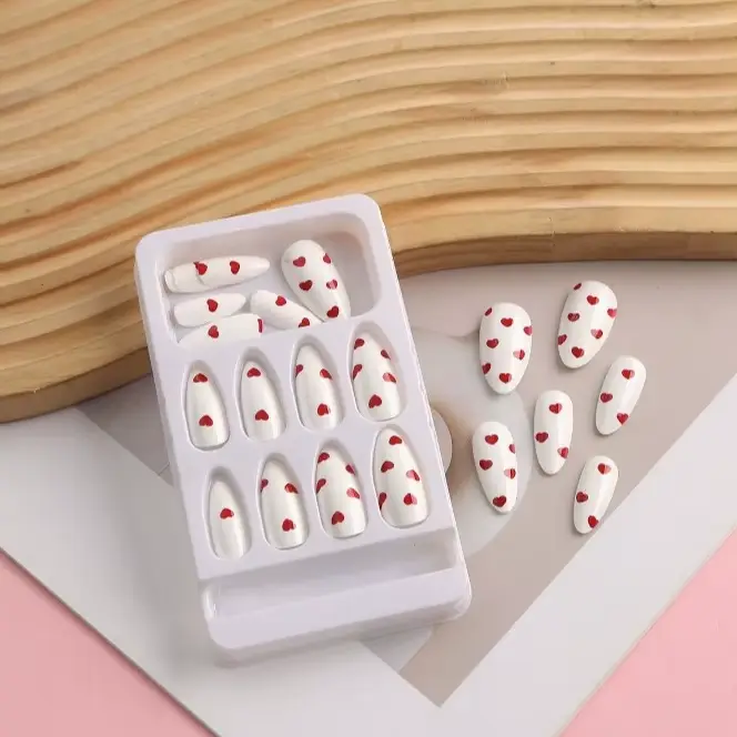 Faux ongles à presser blancs avec base rouge vin et motif cœur