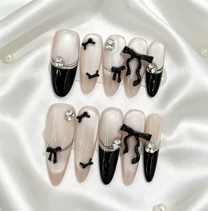 Faux ongles nude noirs style français avec nœud papillon