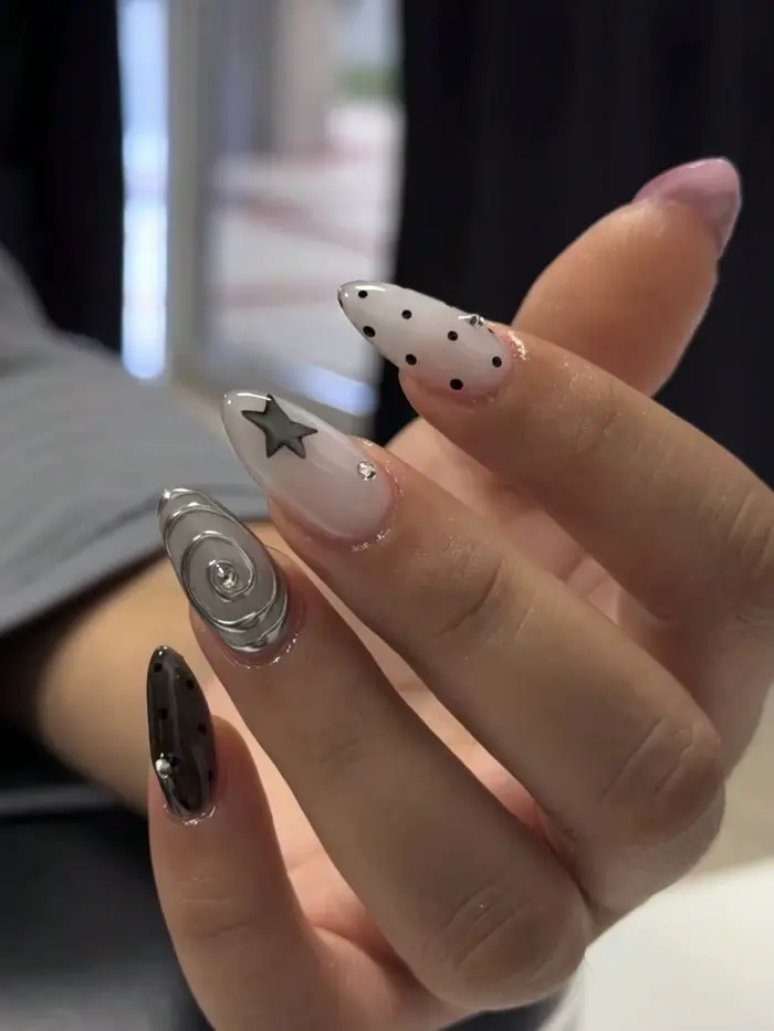 10 faux ongles de taille moyenne en forme d'amande, style Millennium Dark avec des pois étoilés noirs et blancs, ornés de motifs tourbillonnants argentés métalliques et de décorations étoiles 3D Faux