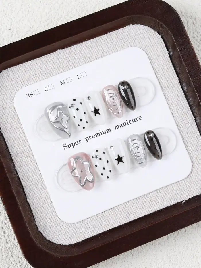 10 faux ongles de taille moyenne en forme d'amande, style Millennium Dark avec des pois étoilés noirs et blancs, ornés de motifs tourbillonnants argentés métalliques et de décorations étoiles 3D Faux