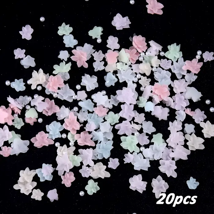 Décorations d'ongles aux fleurs colorées, avec une palette de couleurs fraîches, accompagnées de per