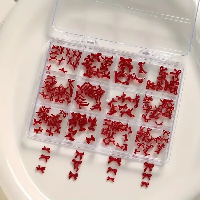 Une boîte de 12 accessoires d'art d'ongle à nœud coloré et doux