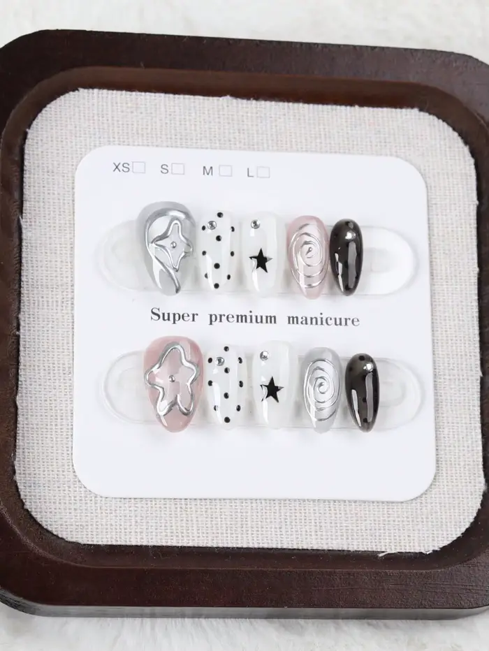 10 faux ongles de taille moyenne en forme d'amande, style Millennium Dark avec des pois étoilés noirs et blancs, ornés de motifs tourbillonnants argentés métalliques et de décorations étoiles 3D Faux