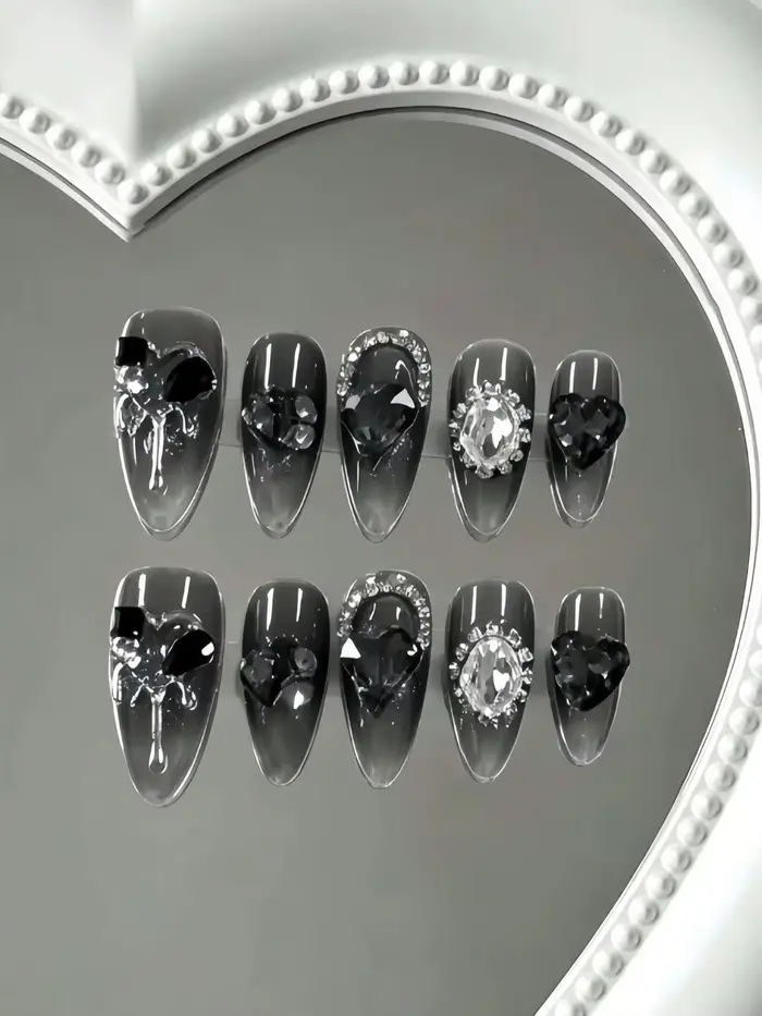10 faux ongles de longueur moyenne en forme d'amande, tons translucides noir-gris, avec de grands st
