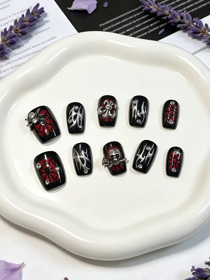 10 ongles courts de forme carrée, aux couleurs principales noir et rouge, décorés d'accessoires méta