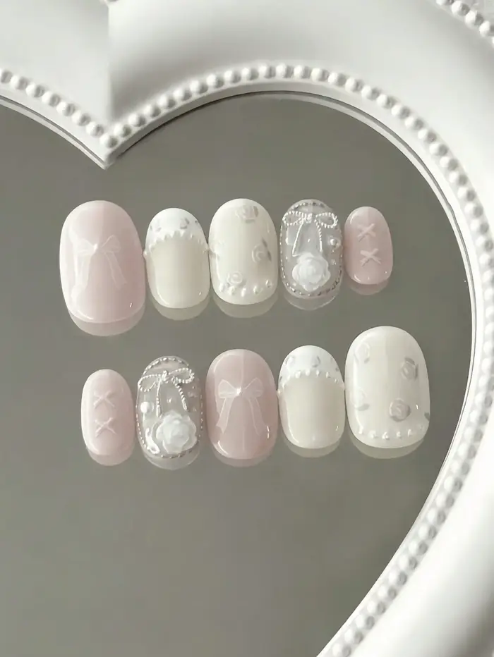 10 faux ongles courts ovales roses et blancs, style ballet, avec roses 3D, nœuds et perles, contrastant avec des détails couleur nude et techniques de gaufrage 3D, adaptés aux jeunes filles et aux fem