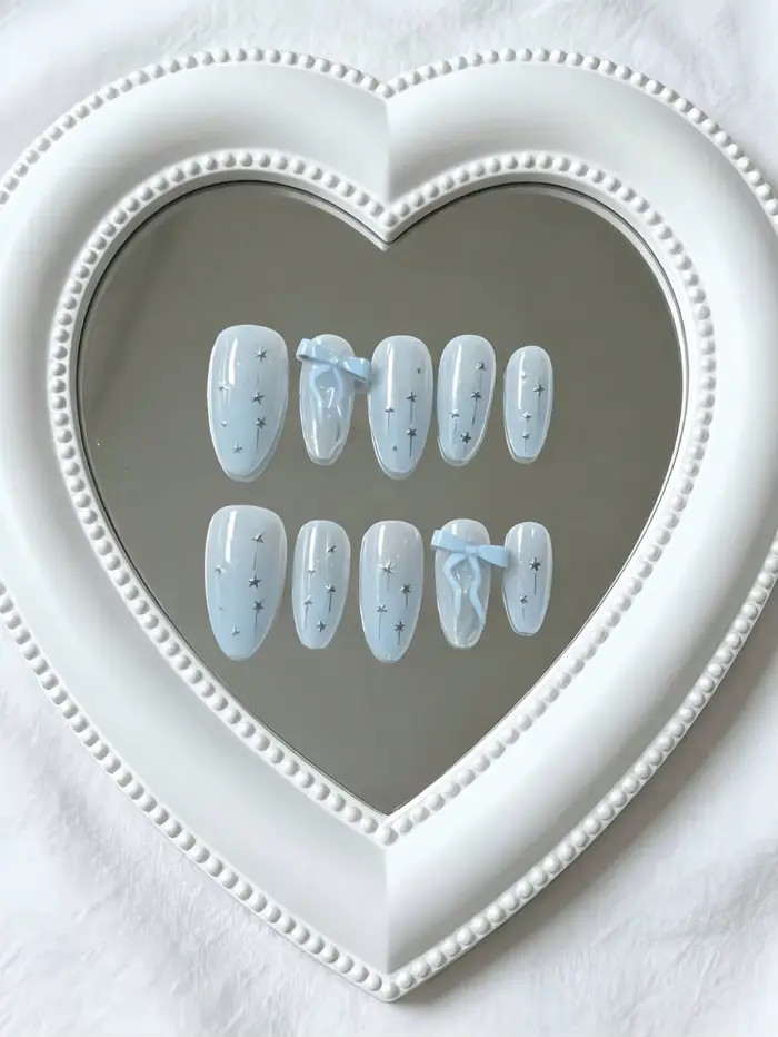 10 faux ongles de longueur moyenne en forme d'amande, avec une base bleu glace transparente, ornés d
