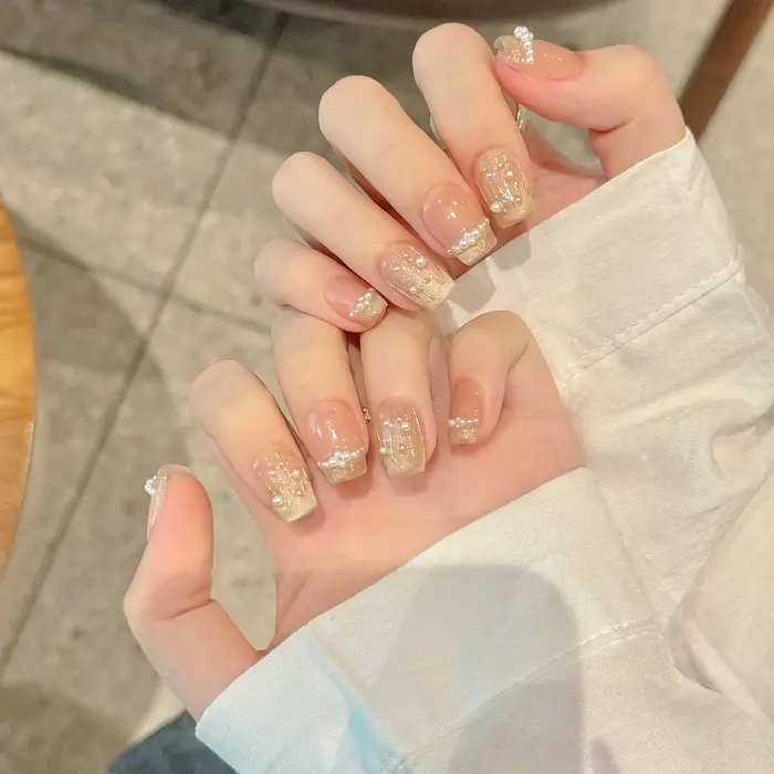Presse à la main sur les ongles paillettes blanc perle décor faux