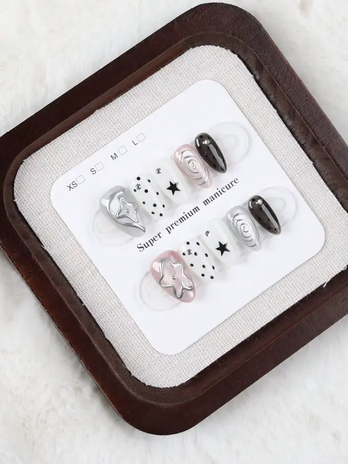10 faux ongles de taille moyenne en forme d'amande, style Millennium Dark avec des pois étoilés noirs et blancs, ornés de motifs tourbillonnants argentés métalliques et de décorations étoiles 3D Faux