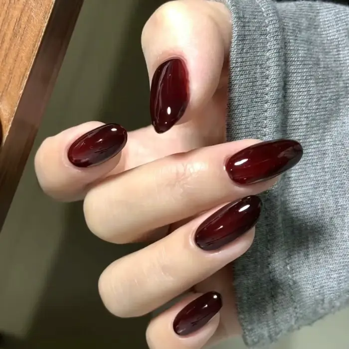 Presse gothique rouge foncé sur les ongles
