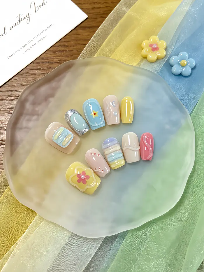 10 ongles courts de forme carrée avec un dégradé multicolore bleu clair, jaune doux, rose nude et ro