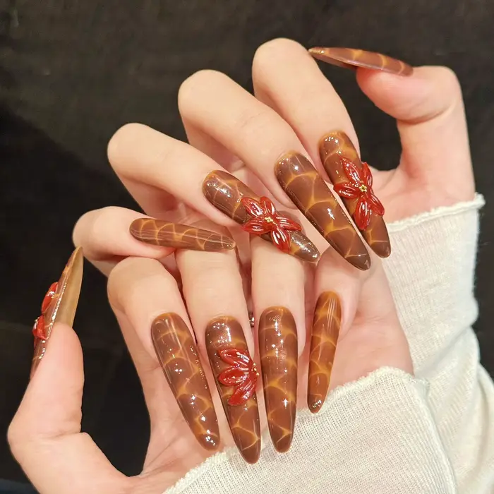 Faux ongles faits main avec motif craquelé marron-orange